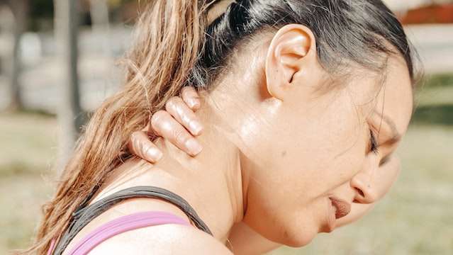 woman rubbing neck after slip-and-fall