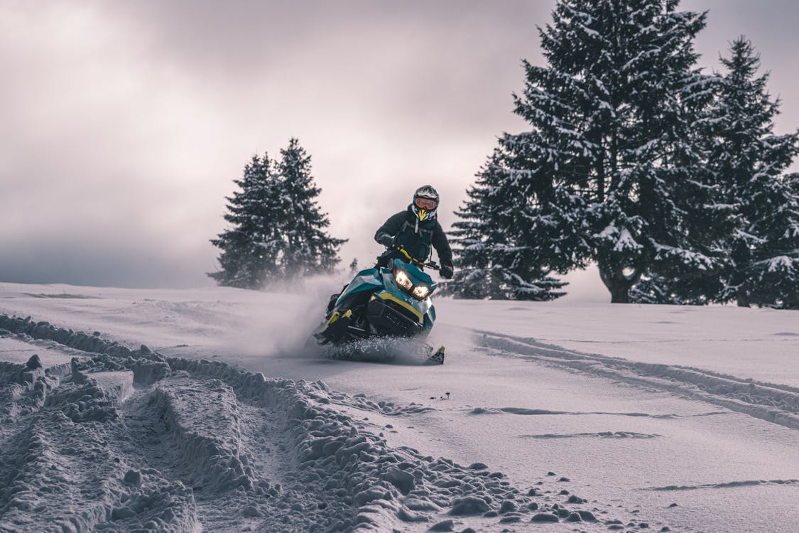person riding snowmobile through deep snow