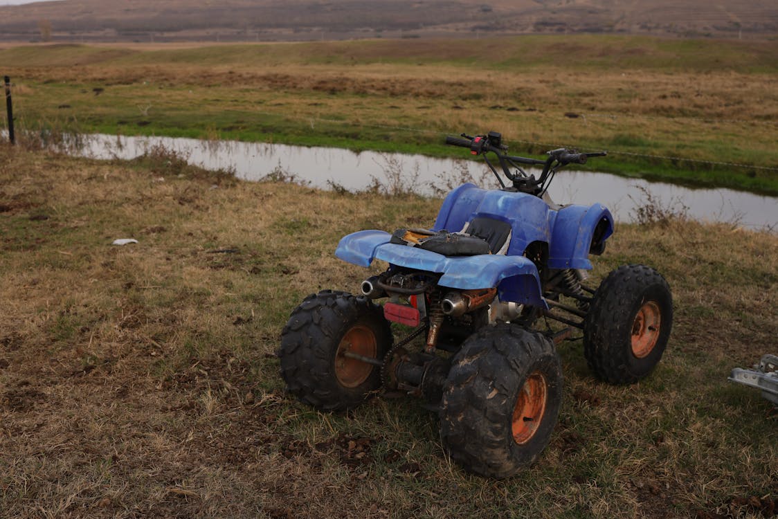 ATV parked near stream in field