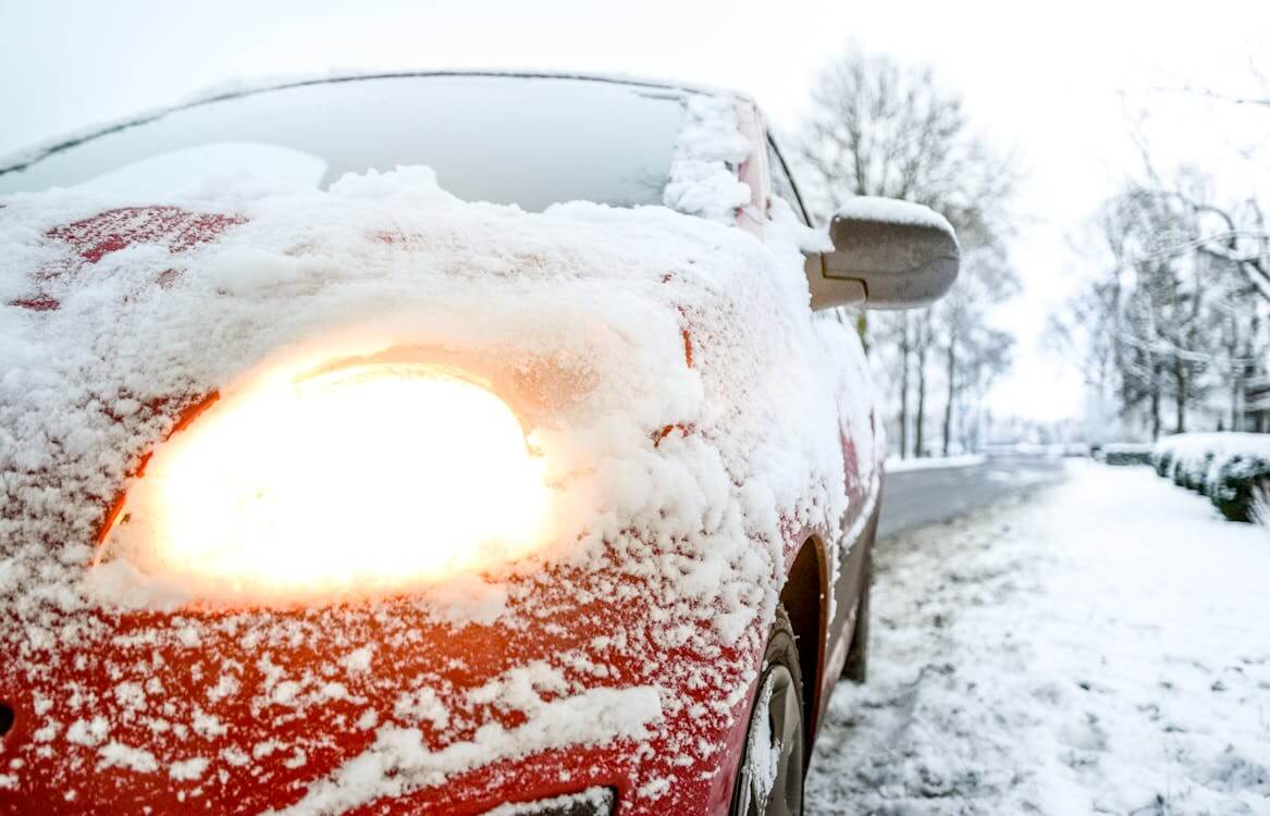 red sedan covered in snow