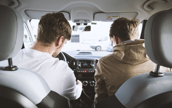 Two people sitting in the front seat of a car