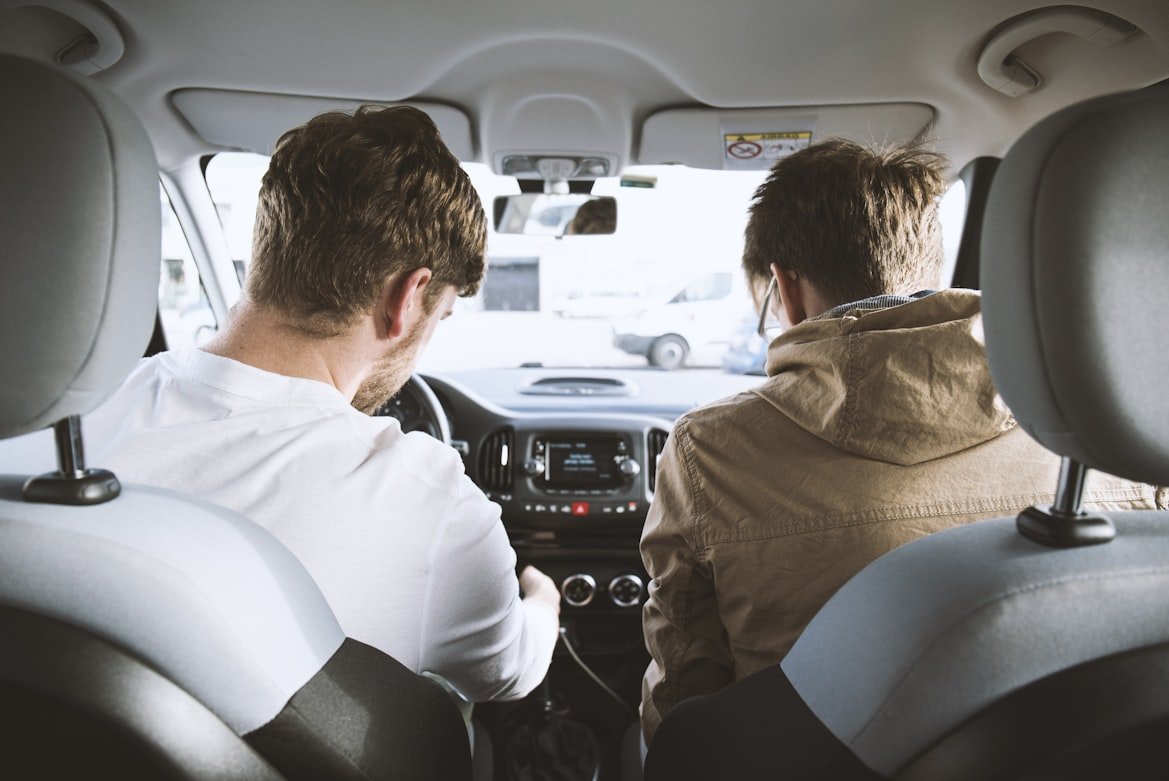 Two people sitting in the front seat of a car